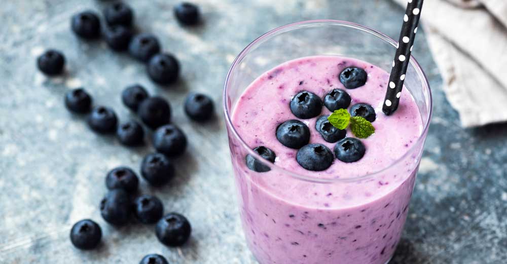 Blueberry smoothie, next to a pile of blueberries