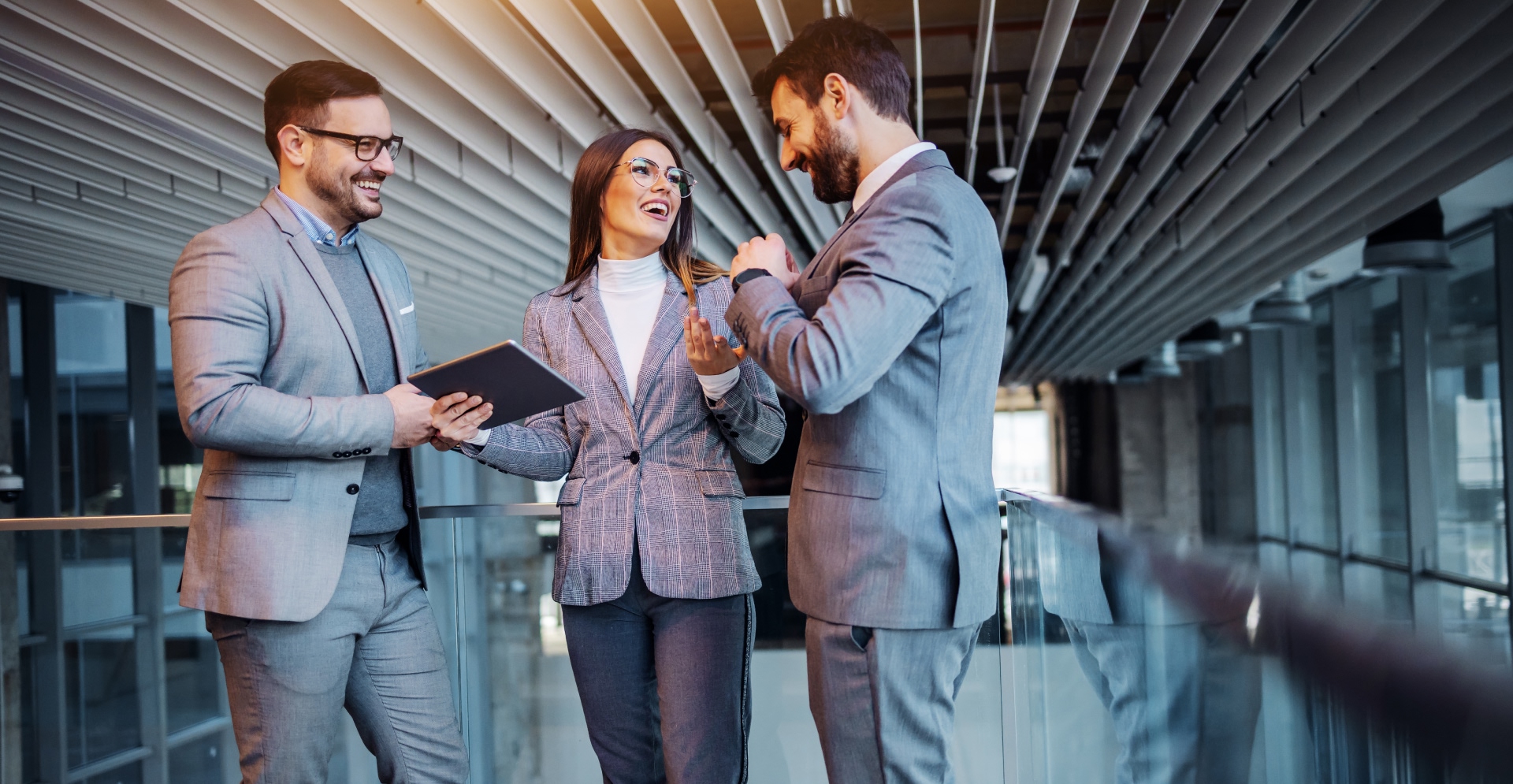 Group of cheerful real estate agents standing in the building in construction process and chatting. They taking a break form hard work. Woman in the middle holding tablet