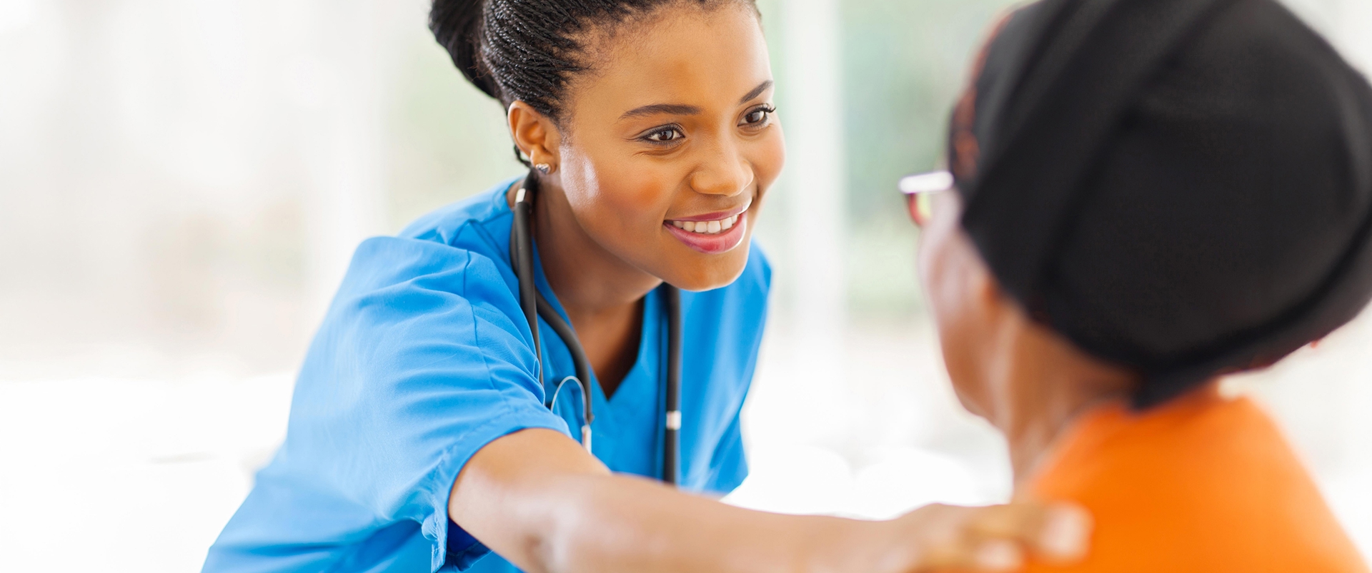 African medical nurse comforting senior patient
