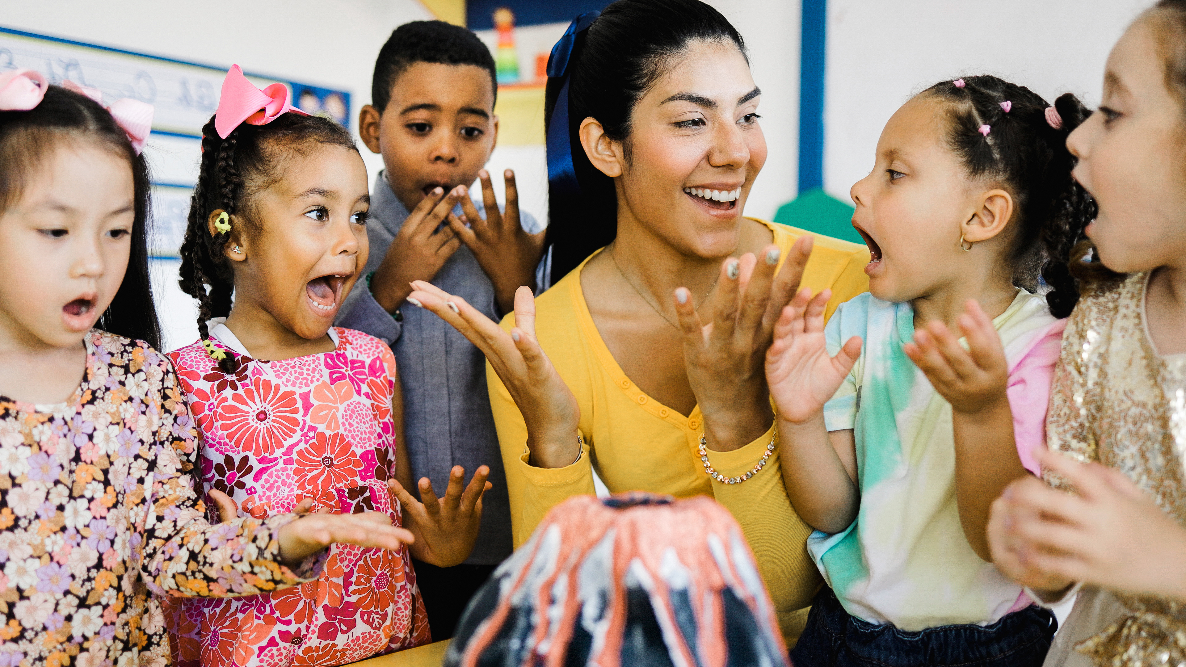 Teacher and children excitedly watch a science experiment.