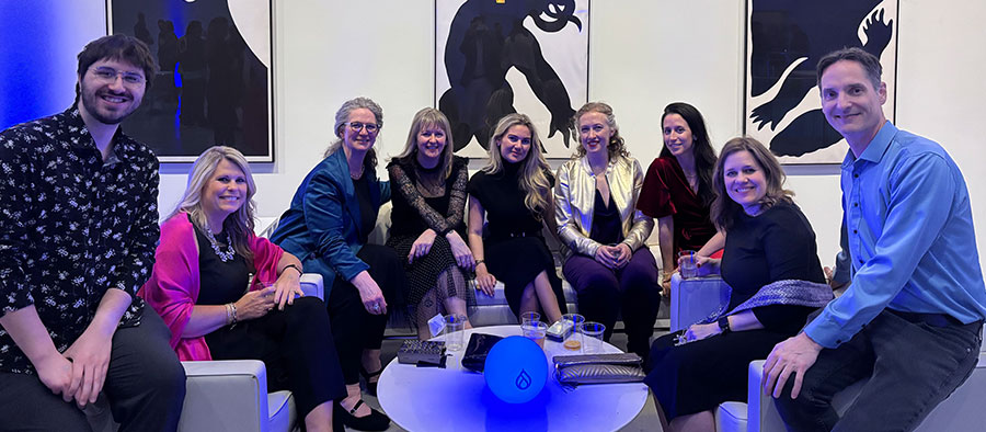 Sandstormers sitting on couches at the DrupalCon Gala.