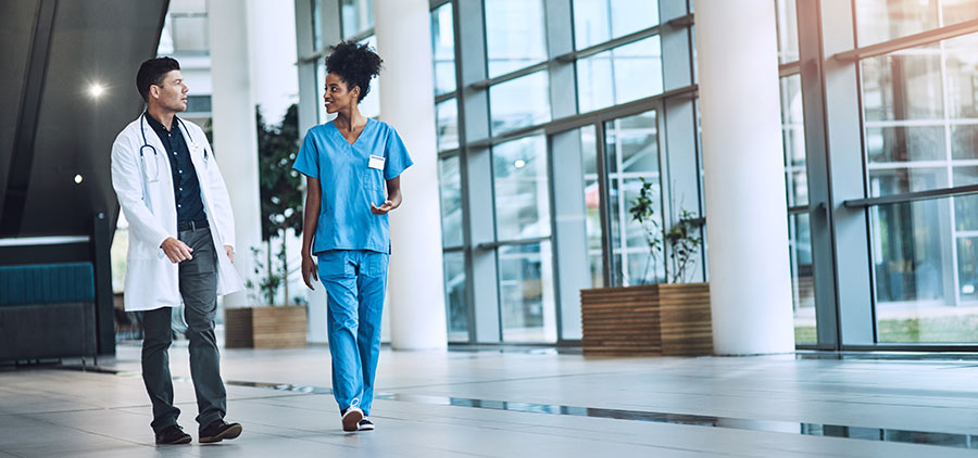 Doctor and nurse walking in a modern hospital corridor