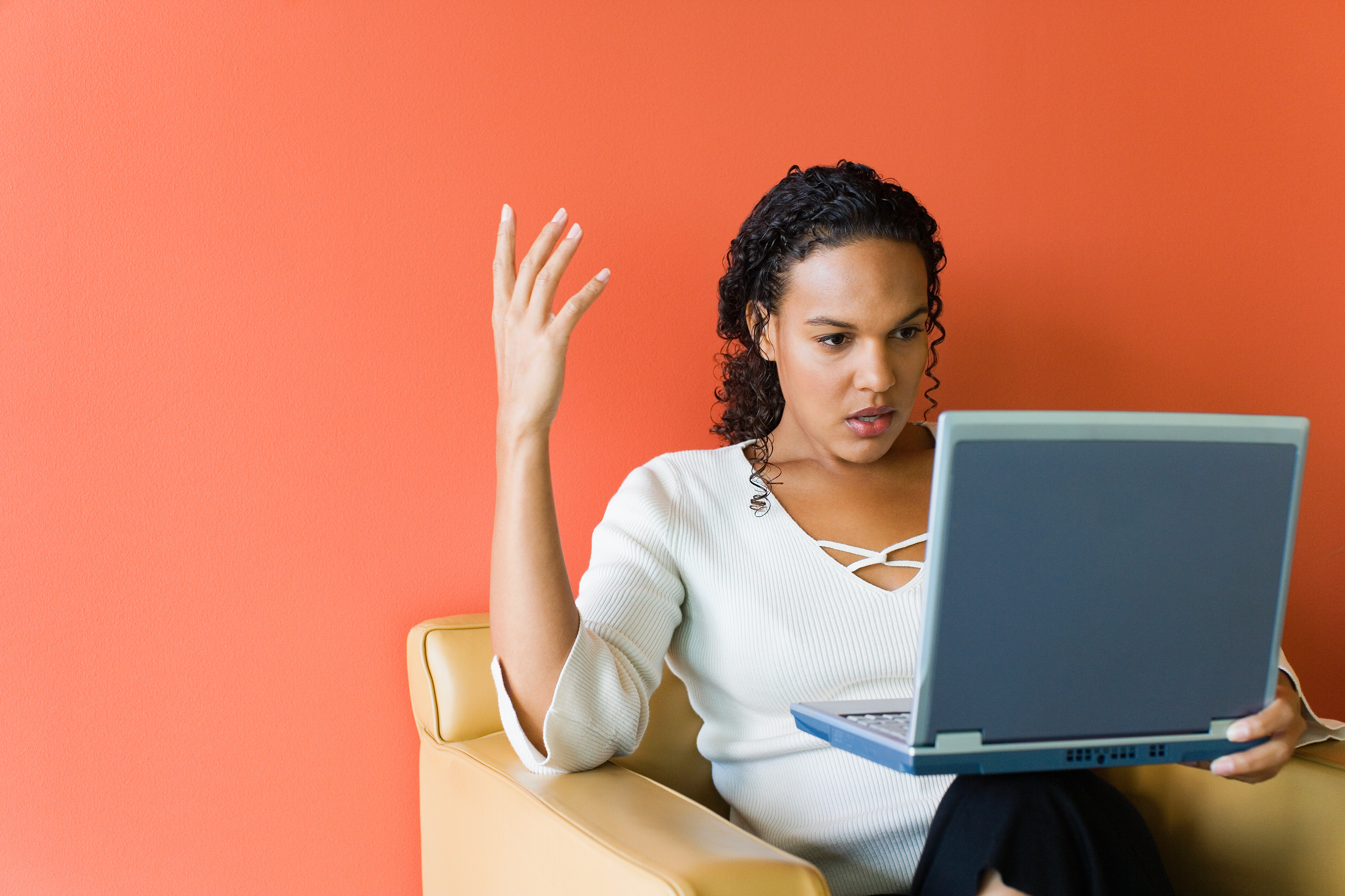 Woman raises her hand in frustration while browsing online