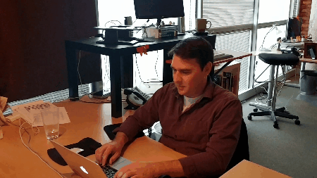 A gif of several people working on laptops in an office together.