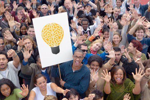 Crowd with lightbulb sign demonstrating the thinking behind marketing strategy.