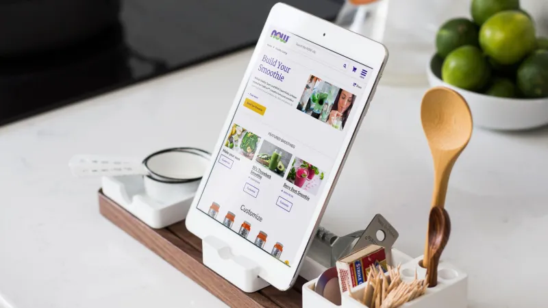 tablet sitting on a countertop showing the Now Foods Smoothie builder web page. tablet is sitting in front of a bowl of limes