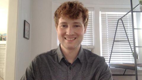 David Boocock a light skinned male with red hair wearing a grey shirt