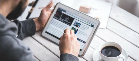 Caucasian male holding a tablet, stylus in other hand