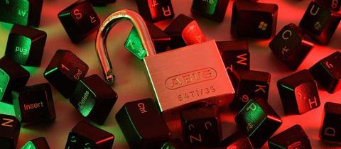 A red and green tinted image of a unlocked lock that is resting on top of, and surrounded by, various computer keyboard keys