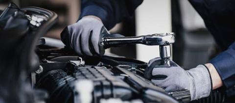 Wrench being used to work on an engine