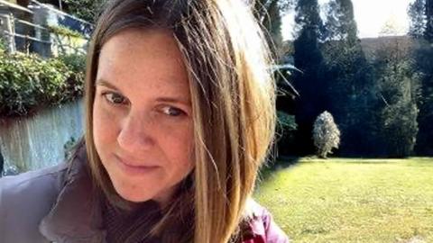 A white female with dark blonde hair outside